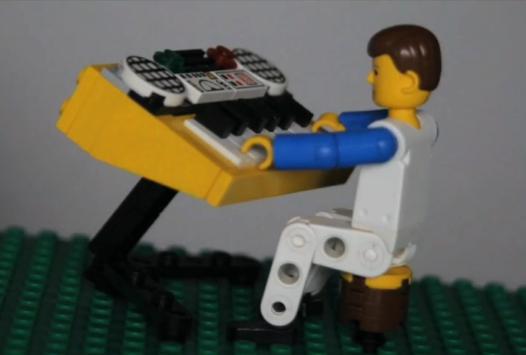 Ilustracja do artykułu przedstawiającego piosenkę Czas jak za Bugiem, przedstawia muzyka z klocków Lego grającego na instrumencie.